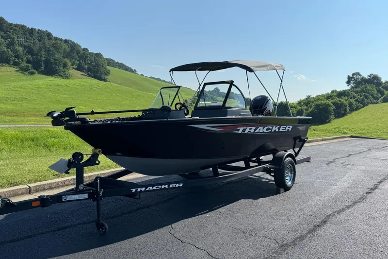 Slide: The Image of 2026 Tracker Pro Guide V-175 WT boat on trailer, parked on a scenic road. - 2