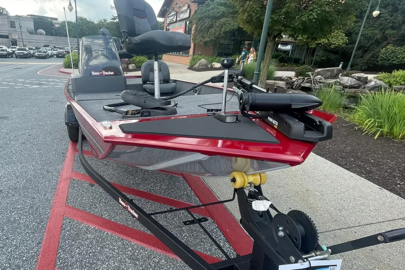 Slide: The Image of 2026 Tracker Bass Tracker Classic XL boat with Minn Kota motor, parked outside a store. - 2