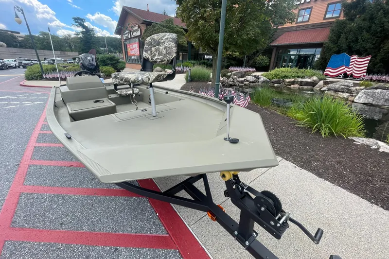 Slide: The Image of 2026 Tracker Grizzly 1754 SC boat displayed outdoors, featuring camouflage seating and a sleek design. - 2