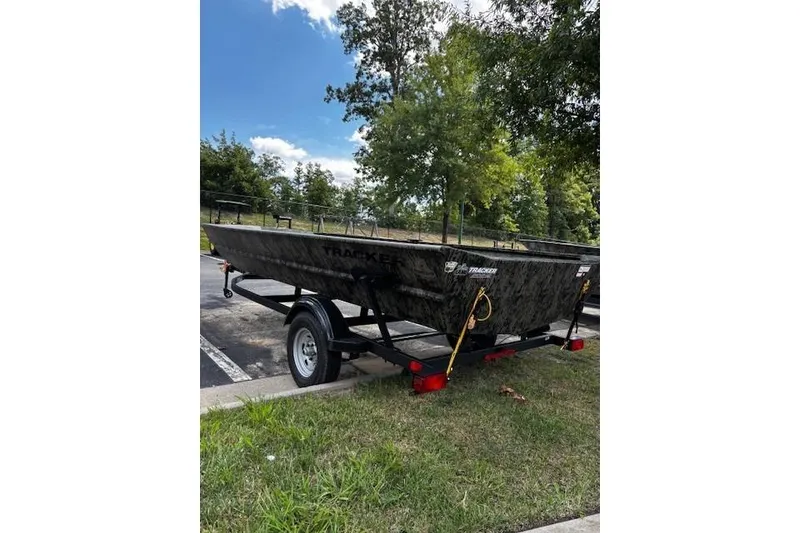 Slide: The Image of 2026 Tracker Grizzly 1860 Utility boat on trailer, parked outdoors. - 2