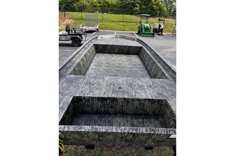 Slide: The Image of 2026 Tracker Grizzly 1860 Utility boat with camouflage design in a parking lot. - 4