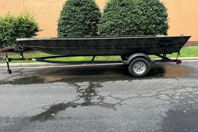 The Image of 2026 Tracker Grizzly 1860 Utility boat on trailer, parked outdoors. - 0