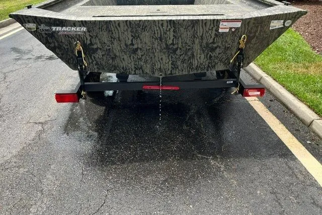 Slide: The Image of 2026 Tracker Grizzly 1860 Utility boat on wet pavement, rear view with camouflage pattern. - 3