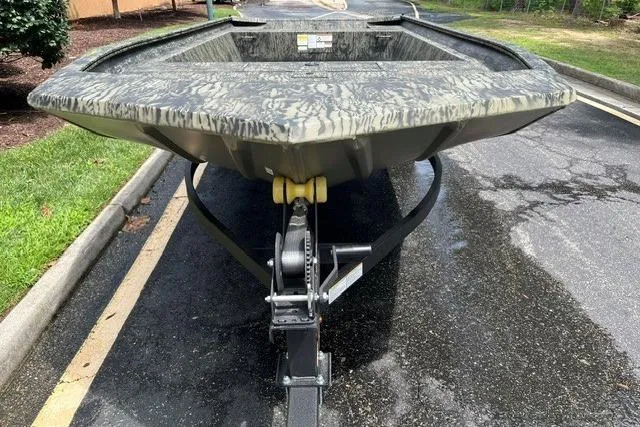 Slide: The Image of 2026 Tracker Grizzly 1860 Utility boat on trailer, parked on asphalt. - 2