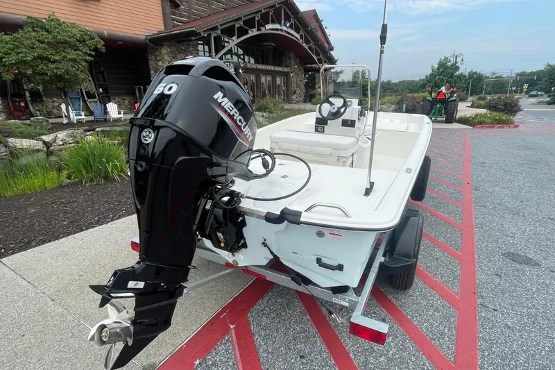 Slide: The Image of 2026 Mako Pro Skiff 17 CC boat on trailer outside White River Fly Shop. - 1