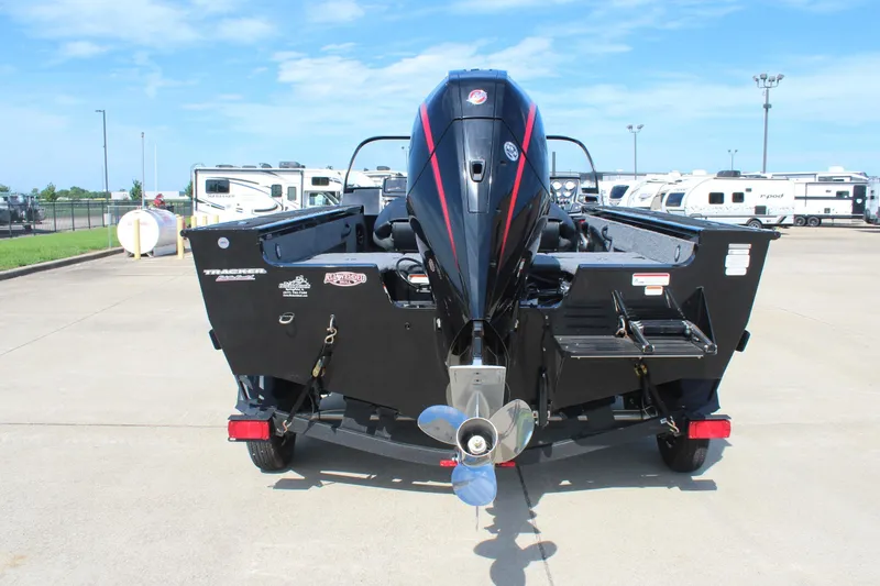 Slide: The Image of 2026 Tracker Targa V-18 Combo boat, rear view with outboard motor, parked outdoors. - 2
