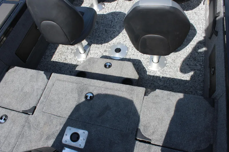 Slide: The Image of 2026 Tracker Targa V-18 Combo boat interior with gray carpet and swivel seats. - 9