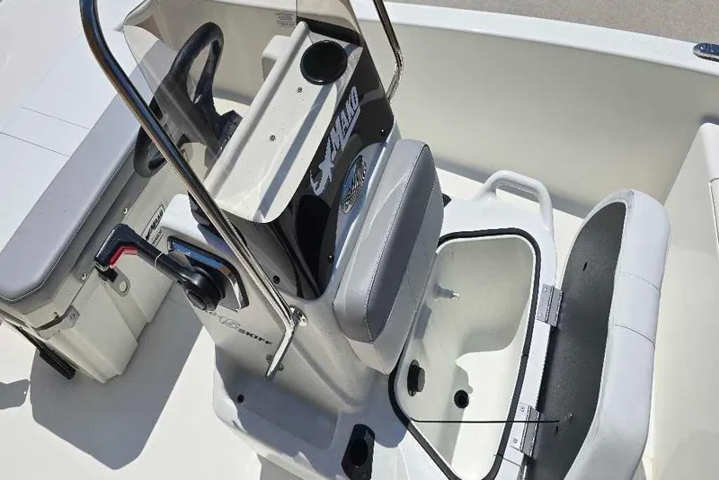 Slide: The Image of 2026 Mako Pro Skiff 15 CC boat interior with steering console and storage compartment. - 60