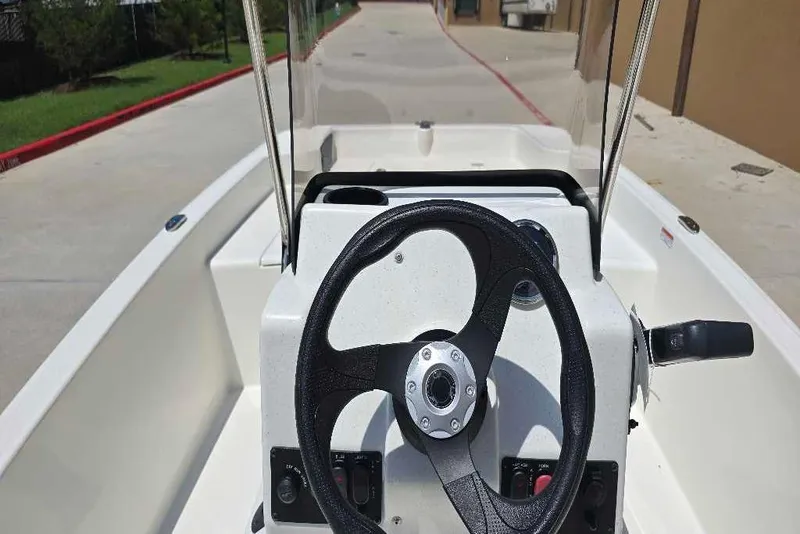 Slide: The Image of 2026 Mako Pro Skiff 15 CC boat console with steering wheel and controls. - 61