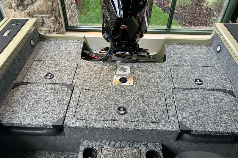 Slide: The Image of Interior view of 2026 Tracker Targa V-18 Combo boat with carpeted flooring and motor. - 7