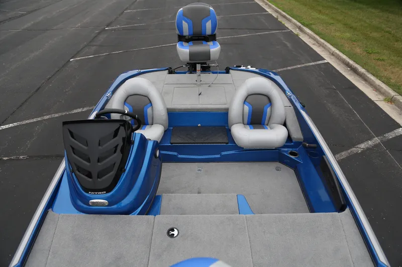 Slide: The Image of 2026 Nitro Z17 boat interior with blue and gray seating, parked on asphalt. - 3