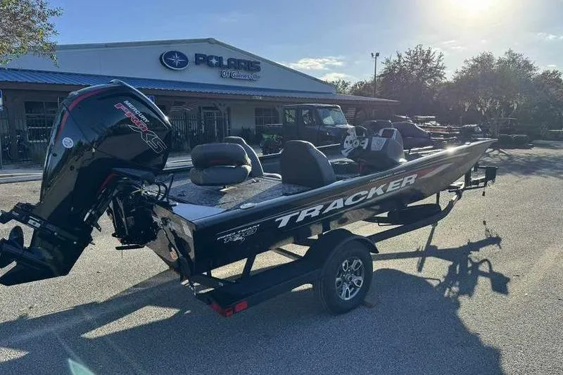 Slide: The Image of 2026 Tracker Pro Team 190 boat on trailer outside dealership in sunlight. - 8