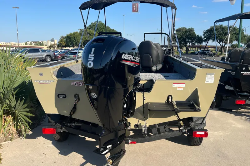 Slide: The Image of 2026 Tracker Targa V-18 WT boat with Mercury engine on trailer, under clear blue sky. - 2
