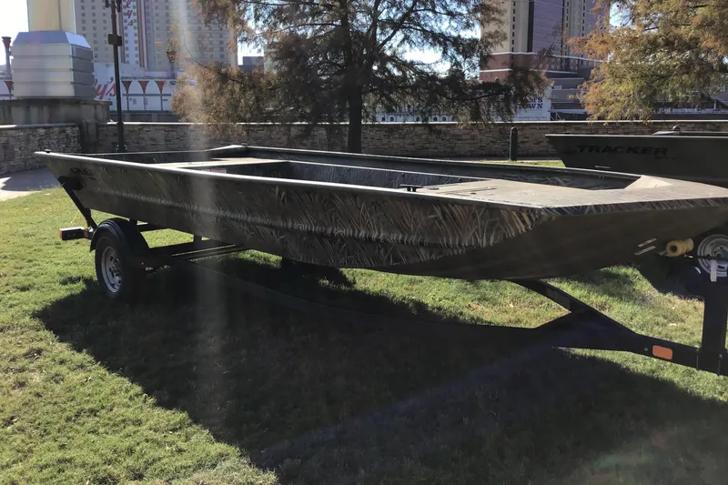 The Image of 2026 Tracker Grizzly 1860 Utility boat on trailer, parked on grass. - 0