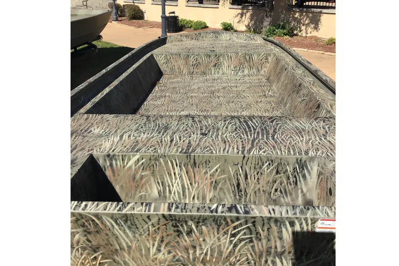 Slide: The Image of 2026 Tracker Grizzly 1860 Utility boat with camouflage pattern, parked outdoors. - 2