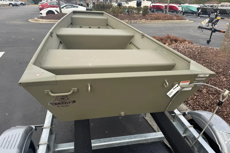 Slide: The Image of 2026 Tracker Grizzly 12 Jon boat on trailer in parking lot. - 3