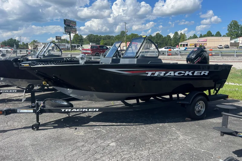 The Image of 2026 Tracker Pro Guide V-175 WT boat on trailer, parked outdoors under a cloudy sky. - 0