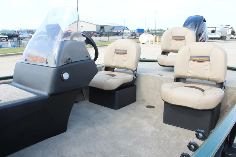 Slide: The Image of 2026 Tracker Bass Tracker Classic Limited boat interior with beige seats and steering console. - 13
