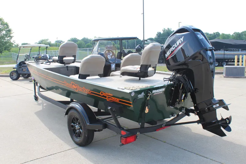 Slide: The Image of 2026 Tracker Bass Tracker Classic Limited boat with Mercury engine on trailer, parked outdoors. - 5