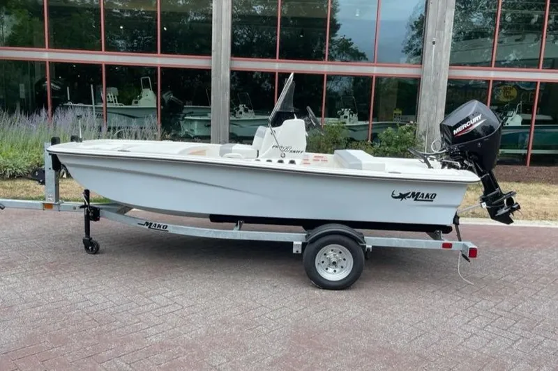 The Image of 2026 Mako Pro Skiff 13 CC boat on trailer, parked outdoors near a building. - 0