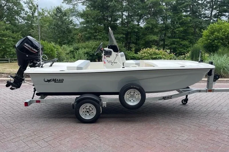 Slide: The Image of 2026 Mako Pro Skiff 13 CC boat on trailer, parked outdoors. - 1