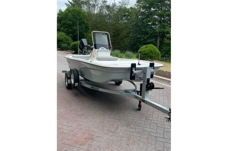 Slide: The Image of 2026 Mako Pro Skiff 13 CC boat on trailer, parked on a brick driveway. - 2