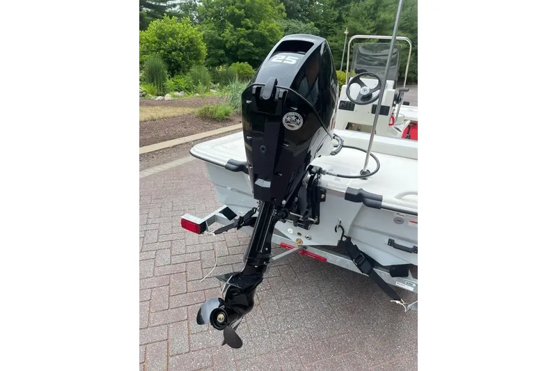 Slide: The Image of 2026 Mako Pro Skiff 13 CC with 25 HP outboard motor, parked on a trailer. - 3