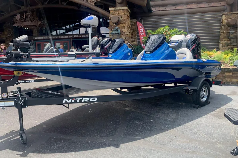 The Image of 2026 Nitro Z17 blue fishing boat on display with trailer in outdoor setting. - 0