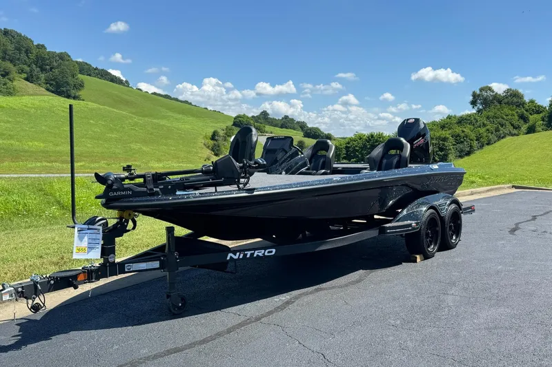 Slide: The Image of 2026 Nitro Z20 XL Pro boat on trailer, parked on asphalt, with green hills in background. - 2
