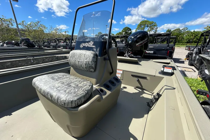 Slide: The Image of 2026 Tracker Grizzly 1860 CC boat with camo seats and Mercury engine, under blue sky. - 3