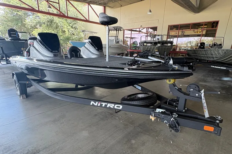 Slide: The Image of 2026 Nitro Z17 boat in showroom, sleek design, black finish, on trailer. - 0