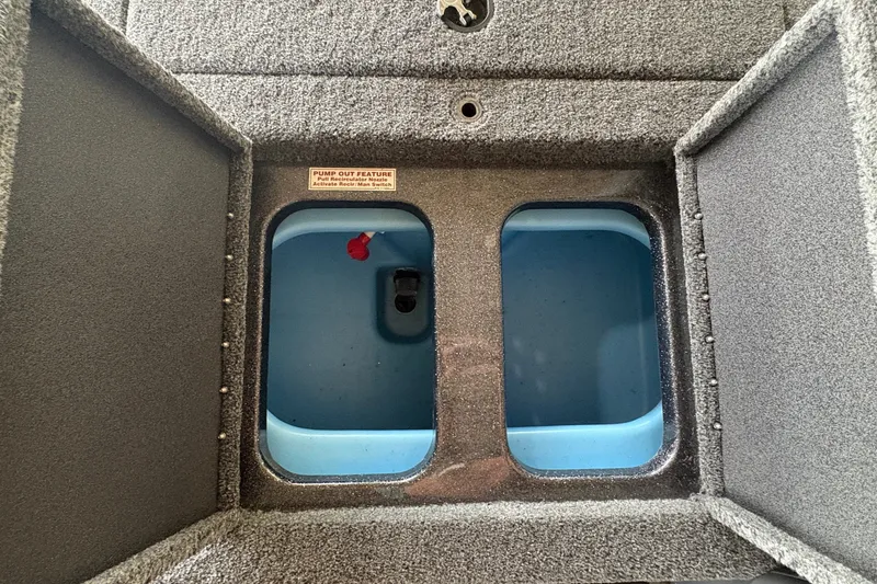 Slide: The Image of An open storage compartment with two blue sections inside, surrounded by gray carpet. - 12