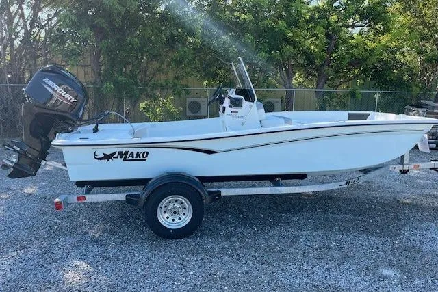 Slide: The Image of 2026 Mako Pro Skiff 15 CC boat on trailer, parked outdoors. - 2