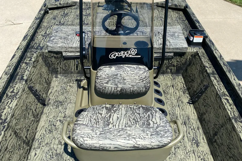 Slide: The Image of 2026 Tracker Grizzly 1860 CC boat interior with camouflage seating and steering console. - 4