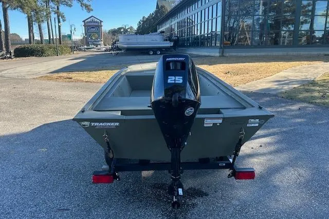 Slide: The Image of 2026 Tracker Grizzly 1648 Utility boat with Mercury 25 engine, parked outdoors. - 2