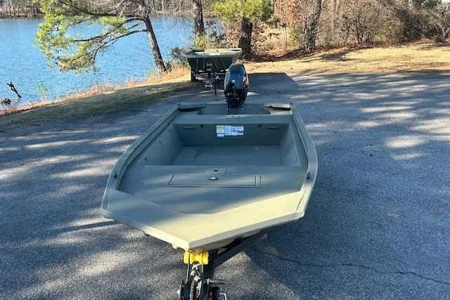 Slide: The Image of 2026 Tracker Grizzly 1648 Utility boat on a trailer near a lake. - 5