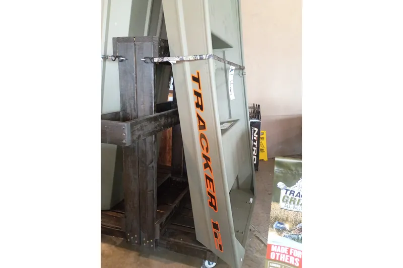 The Image of 2026 Tracker Grizzly 12 Jon boat displayed vertically in a showroom. - 0