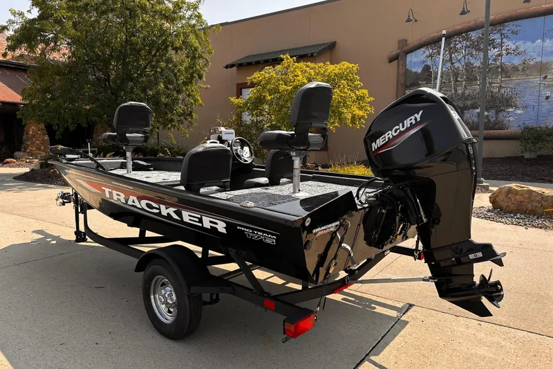 Slide: The Image of 2026 Tracker Pro Team 175 Crappie Edition boat with Mercury engine, parked outdoors. - 2