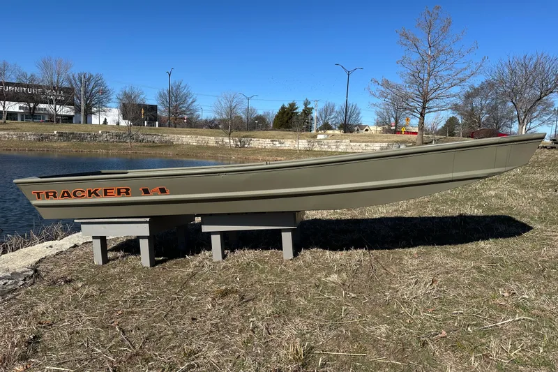 The Image of 2026 Tracker Grizzly 14 Jon boat displayed outdoors near a pond. - 0