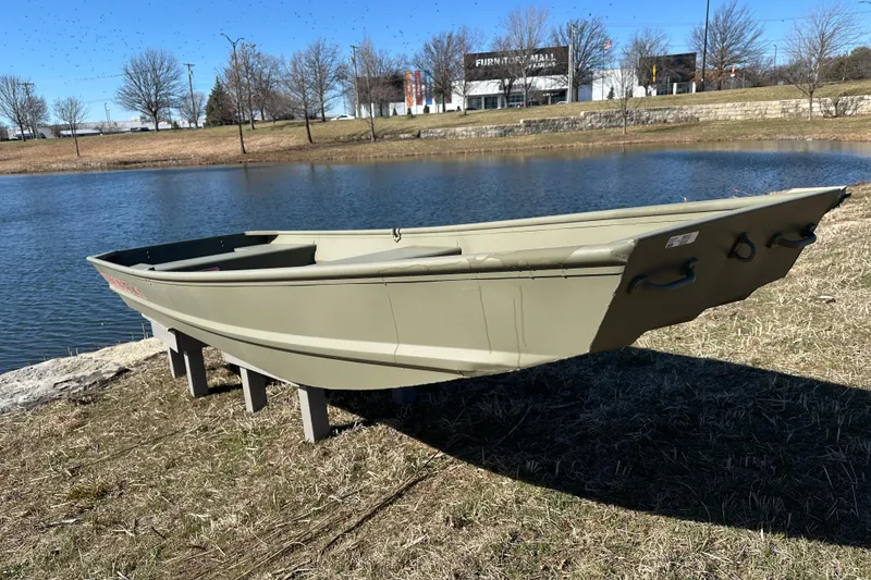 Slide: The Image of 2026 Tracker Grizzly 14 Jon boat displayed by a serene lake. - 2