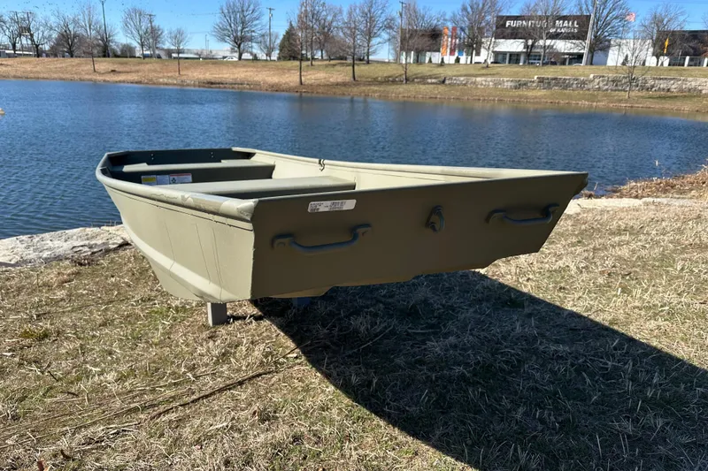 Slide: The Image of 2026 Tracker Grizzly 14 Jon boat by a serene lake. - 4