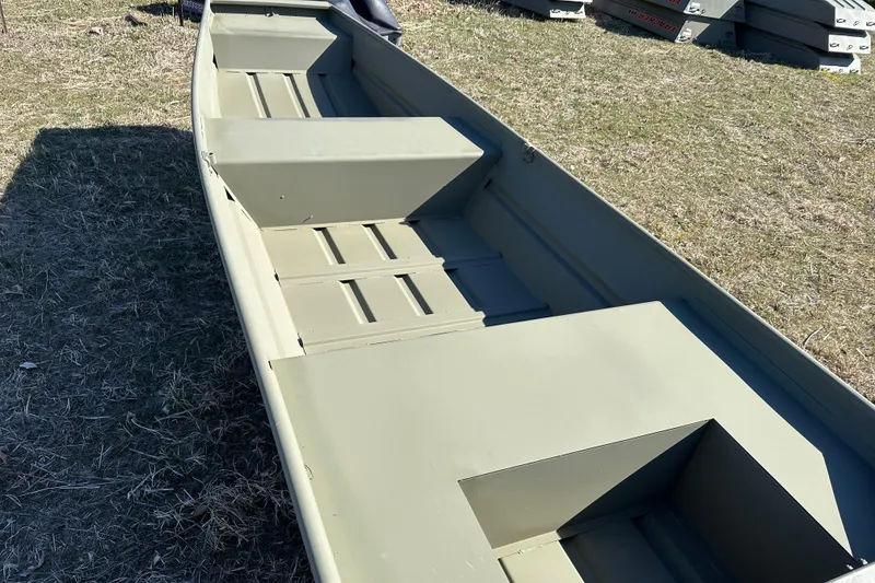 Slide: The Image of 2026 Tracker Grizzly 14 Jon boat on grass, showcasing interior seating and design. - 5