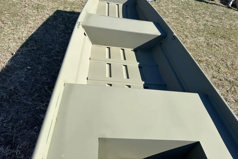 Slide: The Image of 2026 Tracker Grizzly 14 Jon boat interior, showing seating and flooring on grass. - 6