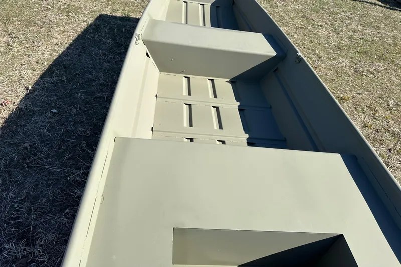 Slide: The Image of 2026 Tracker Grizzly 14 Jon boat on grass, showcasing interior seating and storage. - 7