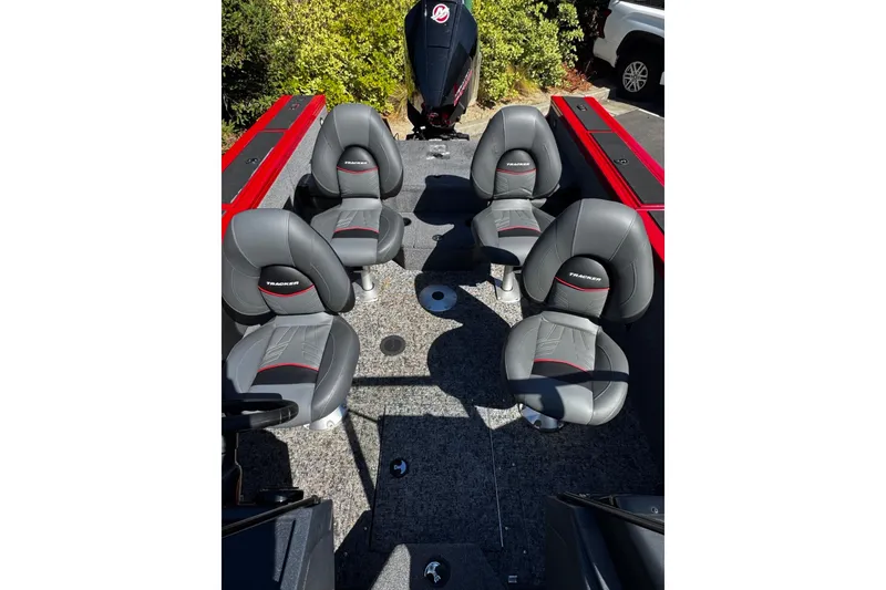 Slide: The Image of 2026 Tracker Targa V-18 Combo boat interior with four gray seats and red accents. - 9