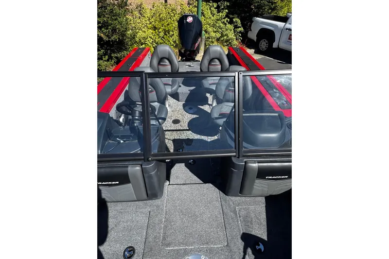 Slide: The Image of 2026 Tracker Targa V-18 Combo boat interior with seating and windshield, parked outdoors. - 7