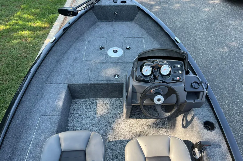 Slide: The Image of 2026 Tracker Super Guide V-16 SC boat interior with steering console and seating. - 2