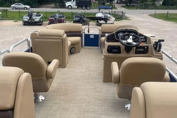 Slide: The Image of 2018 Lowe SS230 Walk-Thru pontoon boat interior with beige seating and steering console. - 4