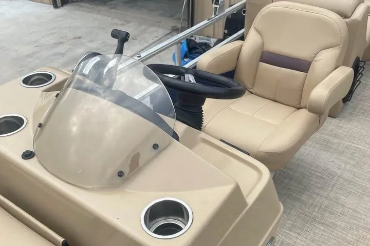 Slide: The Image of 2018 Lowe SS230 Walk-Thru boat interior with steering wheel and beige seating. - 9