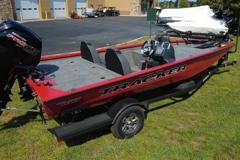 Slide: The Image of 2026 Tracker Pro Team 190 boat with Mercury engine, parked on grass near a building. - 6